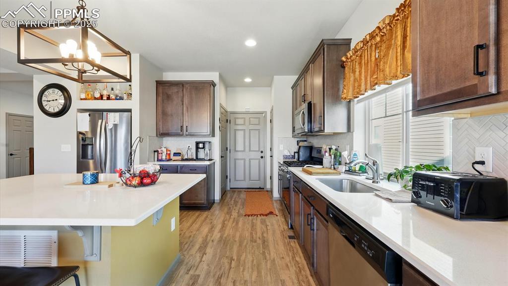 Large island with breakfast bar and ample cabinets and solid countertops for storage and easy food preparation.