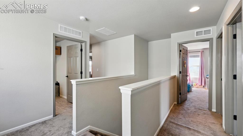 Upstairs hallway with view into the Laundry Room and Primary Bedroom.