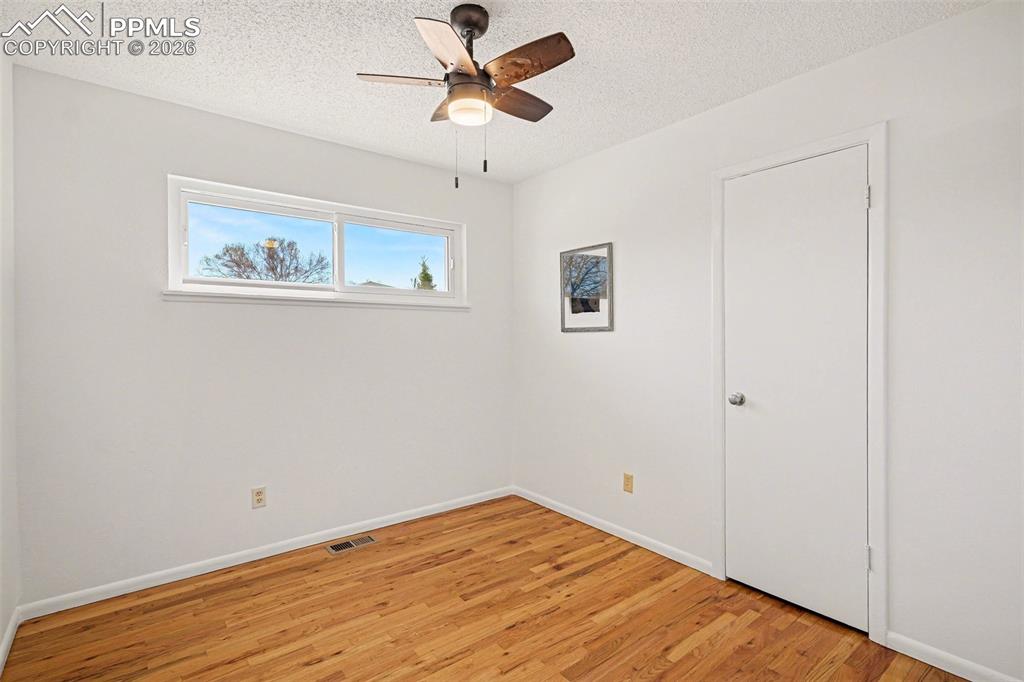 Secondary bedroom with real wood flooring & new ceiling fan