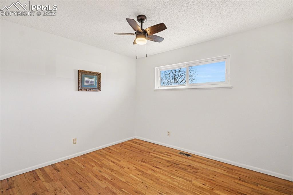 Secondary bedroom with real wood flooring & new ceiling fan