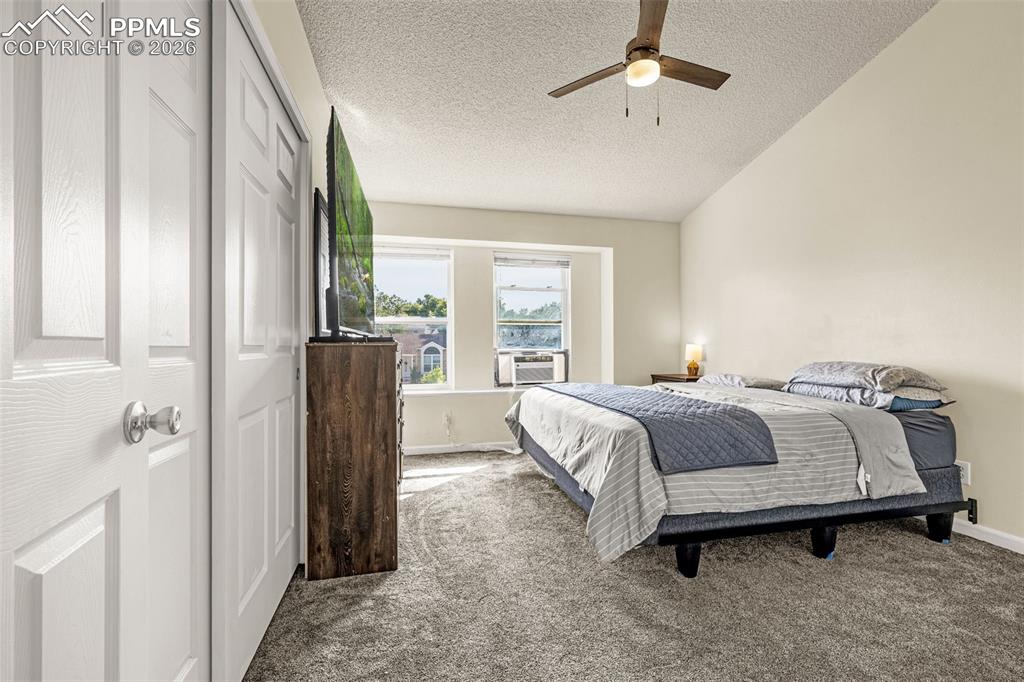 Bedroom featuring carpet, a textured ceiling, a ceiling fan, and a closet
