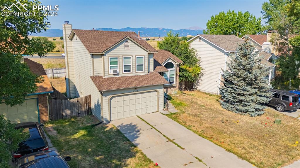 View of front of home featuring a shingled roof, a mountain view, a garage, and concrete driveway