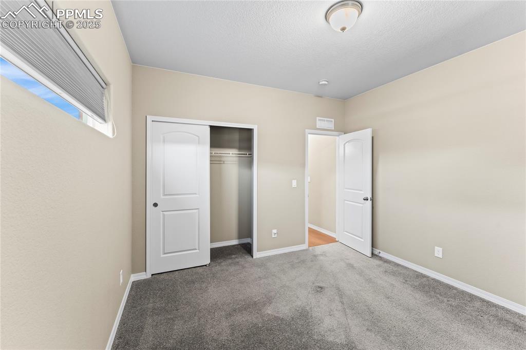 Unfurnished bedroom with carpet floors, a closet, and a textured ceiling