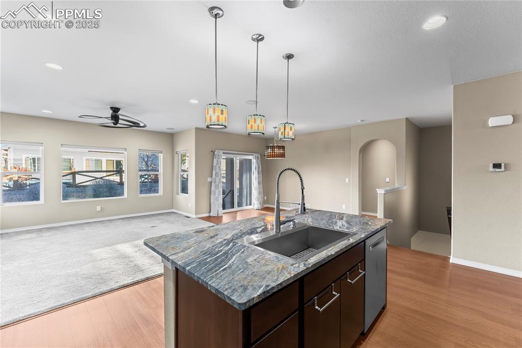 Kitchen featuring dark brown cabinetry, open floor plan, recessed lighting, hanging light fixtures, and ceiling fan