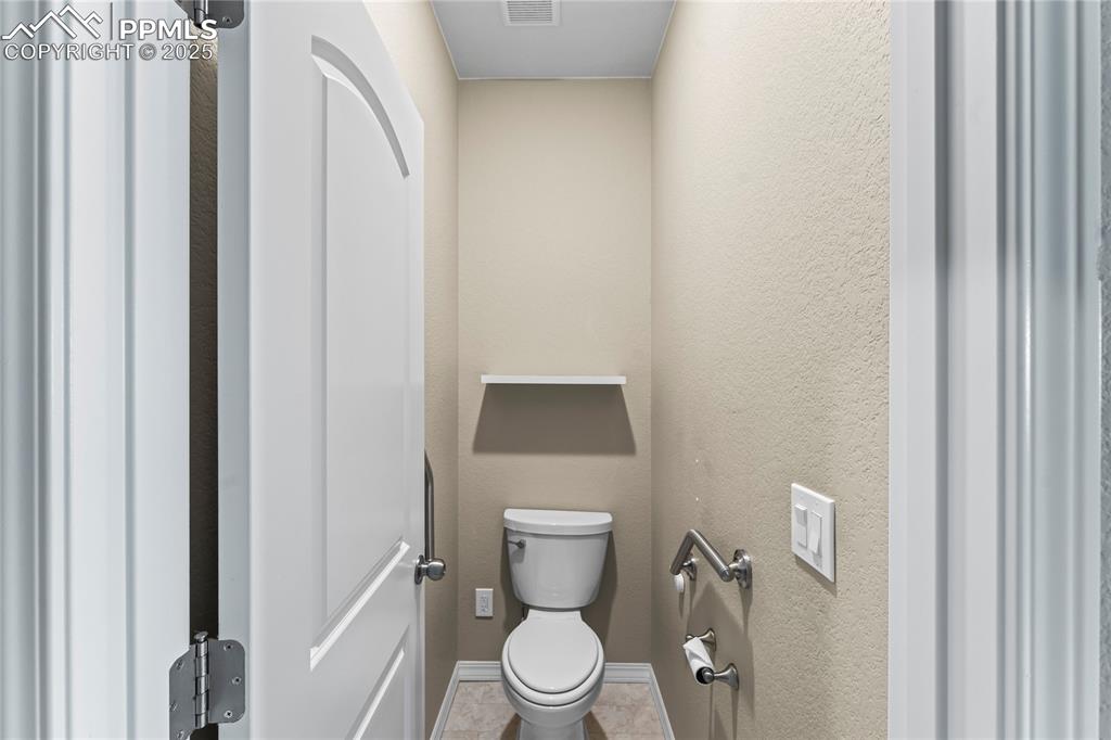 Bathroom featuring a textured wall and tile patterned floors