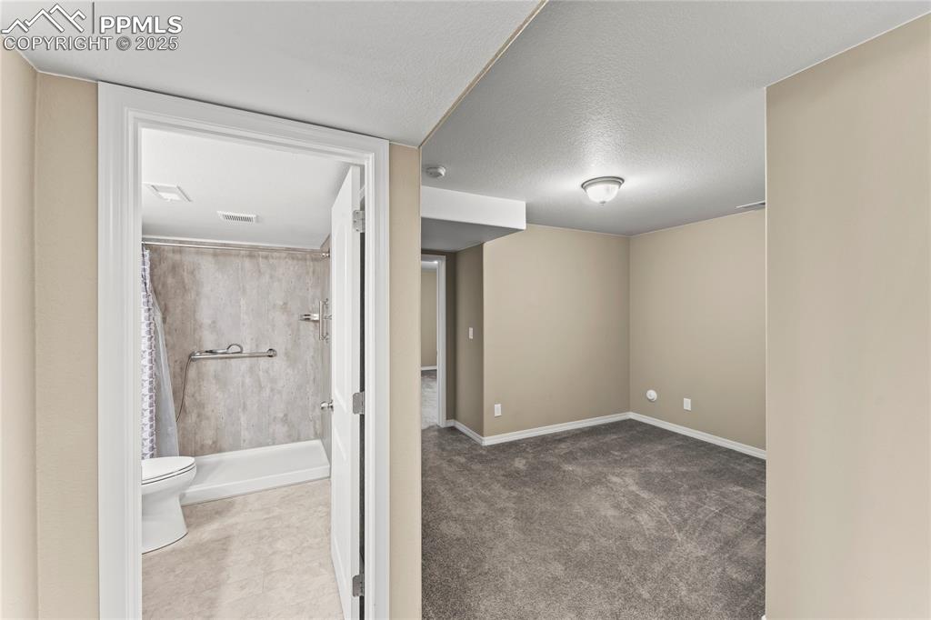 Basement featuring a textured ceiling and carpet