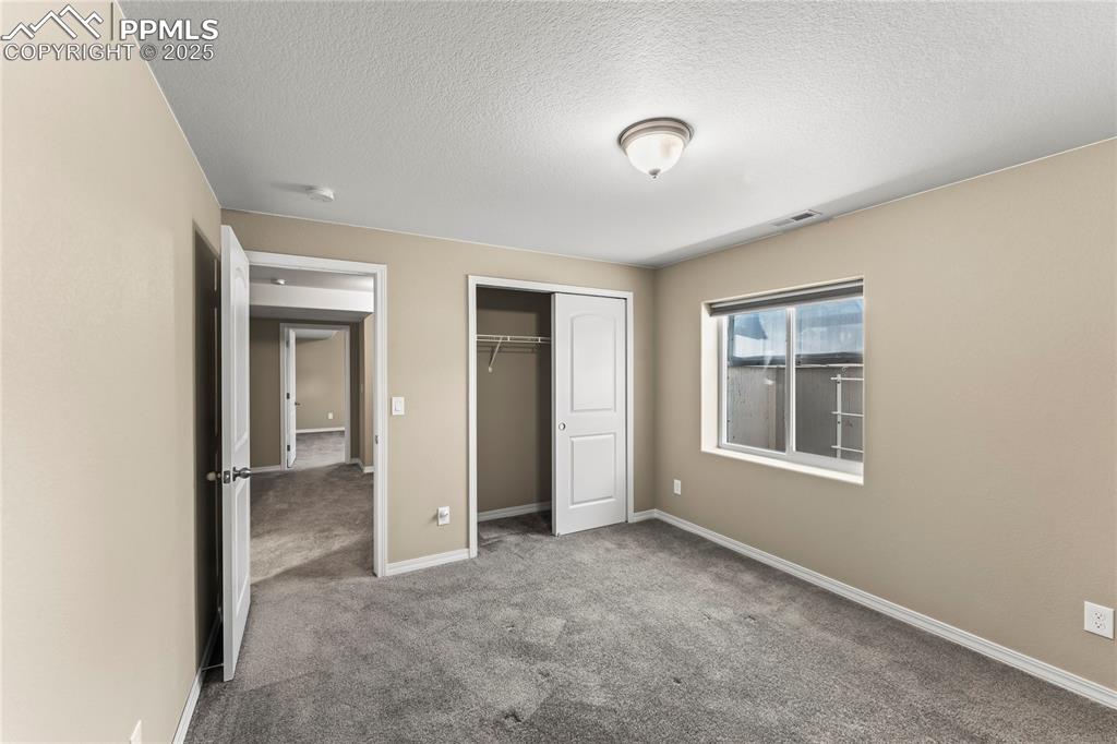 Unfurnished bedroom featuring carpet flooring, a closet, and a textured ceiling