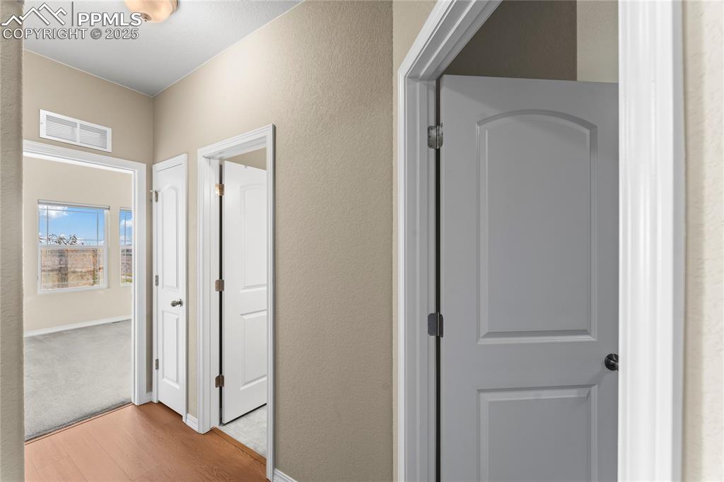 Hall featuring wood finished floors and a textured wall