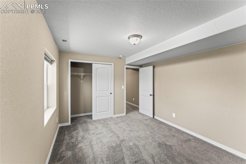 Unfurnished bedroom featuring carpet floors, a closet, and a textured ceiling