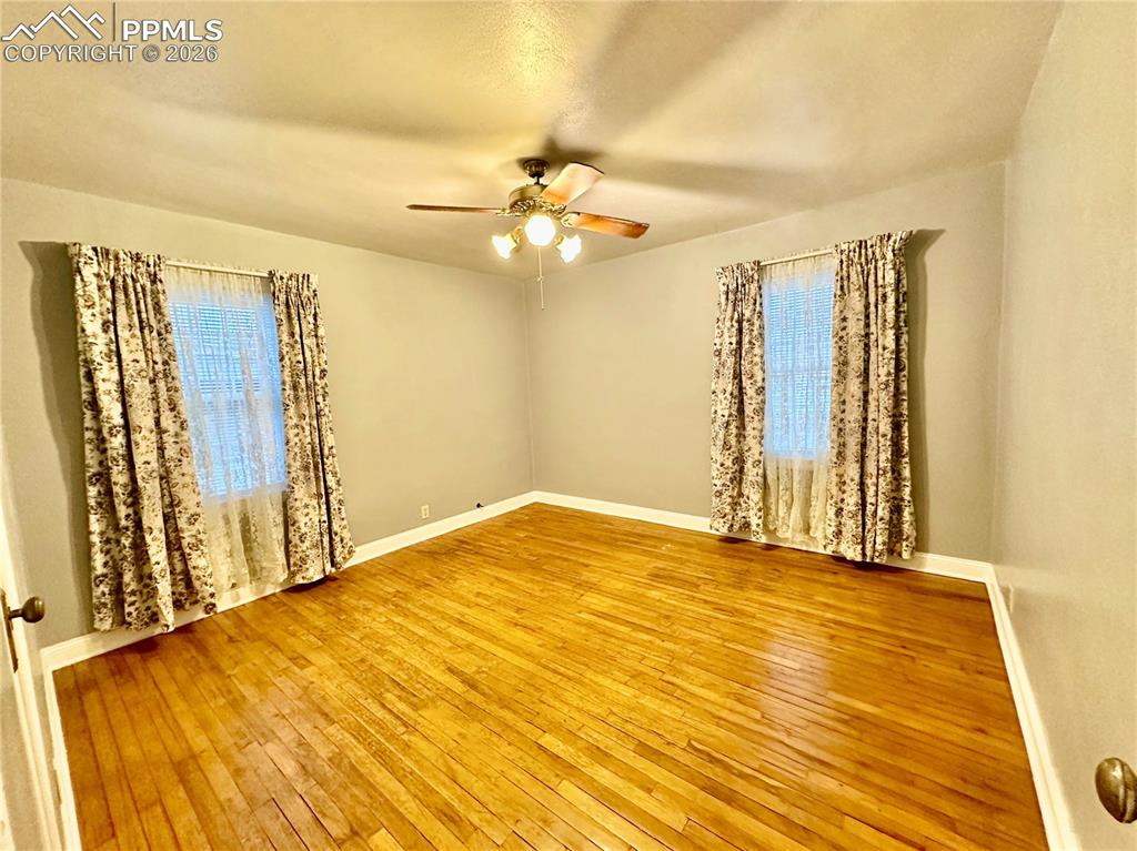 Unfurnished room featuring light wood finished floors and a ceiling fan