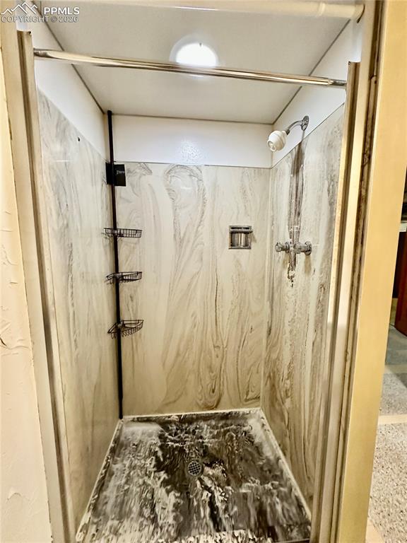 Full bath featuring a marble finish shower