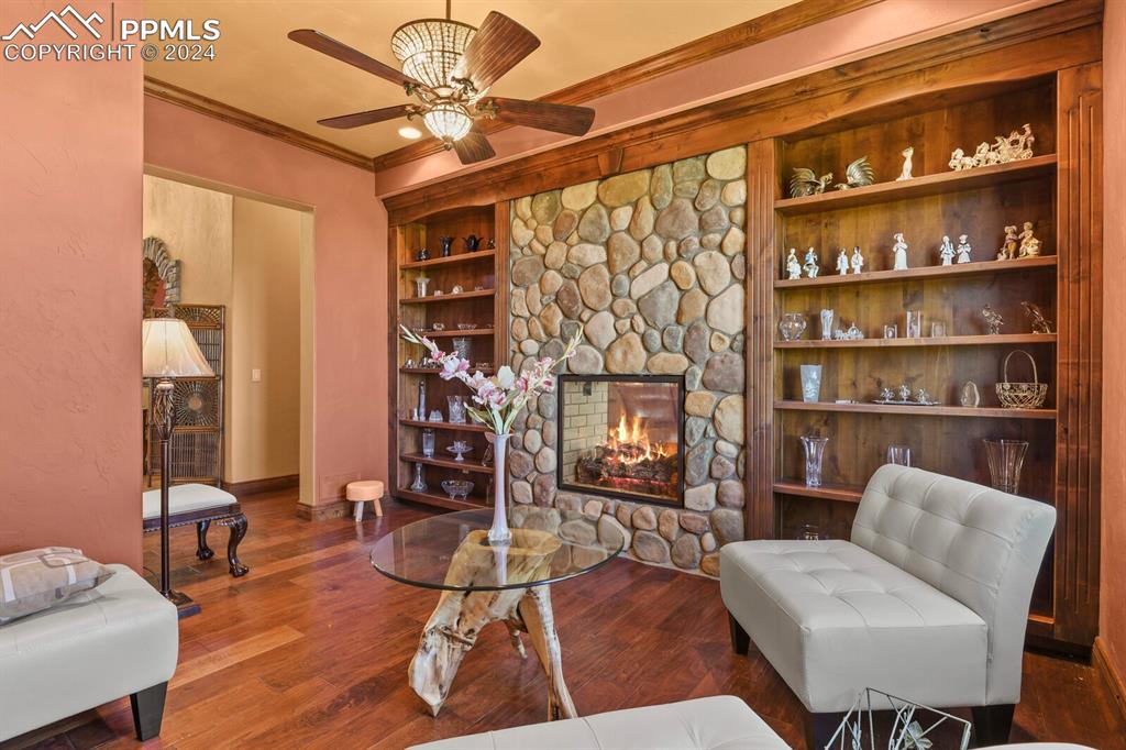 Living room with hardwood / wood-style flooring, a fireplace, and ceiling fan