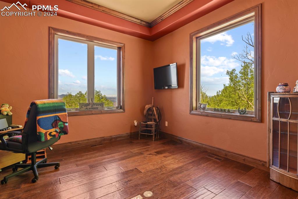 Home office featuring dark hardwood / wood-style floors and crown molding