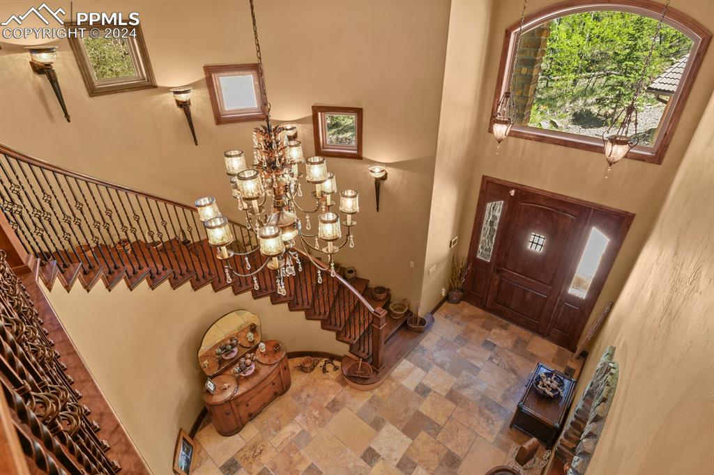 Foyer with a high ceiling, a notable chandelier, and tile flooring