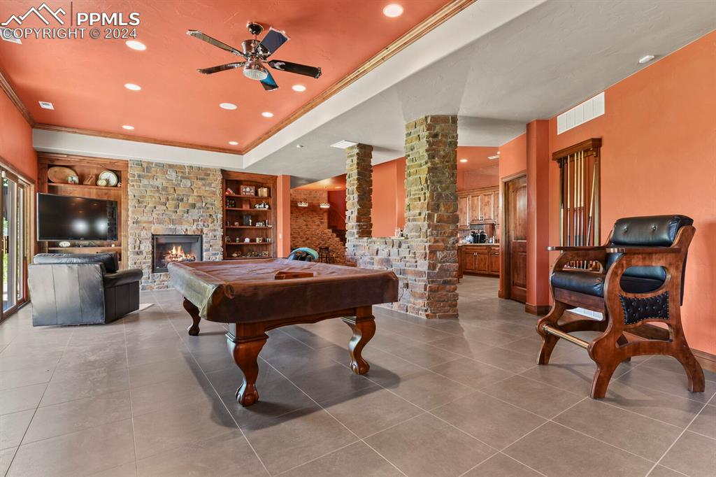 Game room featuring tile floors, a fireplace, billiards, and built in features