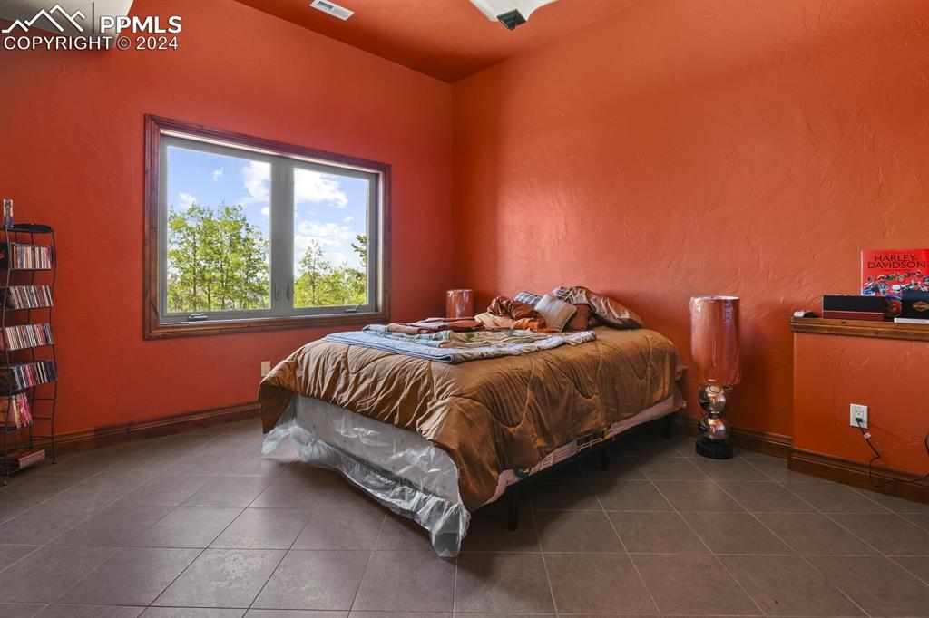 Bedroom with dark tile flooring