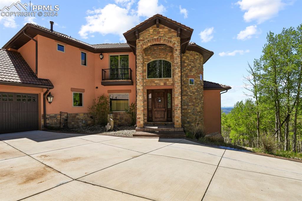 View of front of home featuring a garage and a balcony
