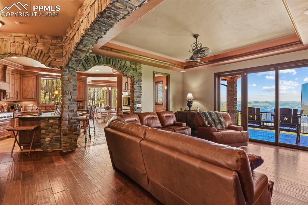 Living room with sink, ornamental molding, hardwood / wood-style flooring, and a tray ceiling