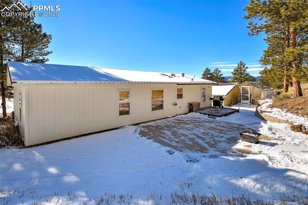 Snow covered Back Yard with Greenhouse, Firepit and Decking for Family BBQs