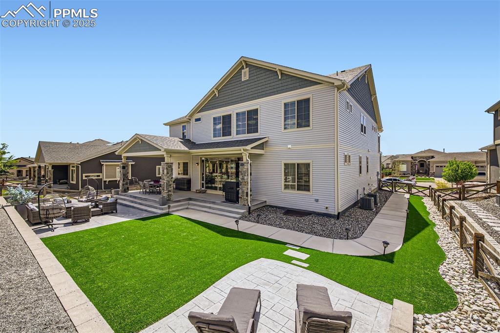 Backyard is a no-maintenance oasis with a covered patio, green space to play, a greenhouse to the side of the home and stamped concrete areas for all of your outdoor furniture!