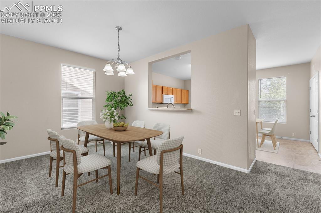 *Virtually Staged* Dining room featuring light carpet, plenty of natural light, and a chandelier