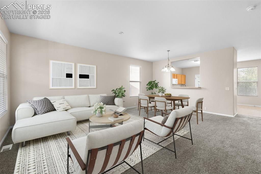 *Virtually Staged* Living room featuring light carpet and a chandelier