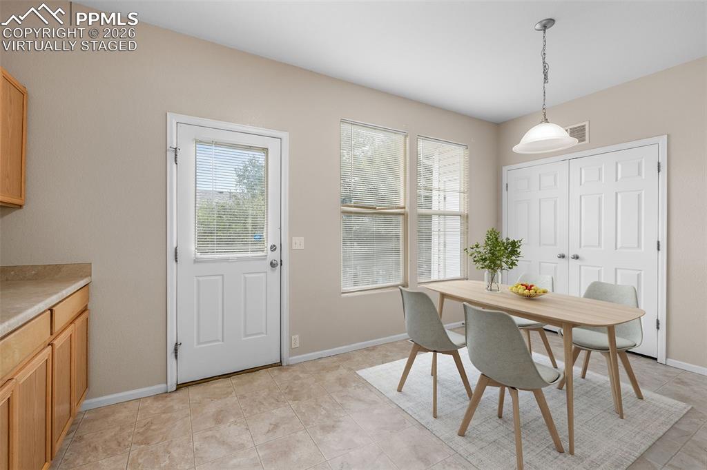 *Virtually Staged* Dining room with plenty of natural light and light tile patterned flooring