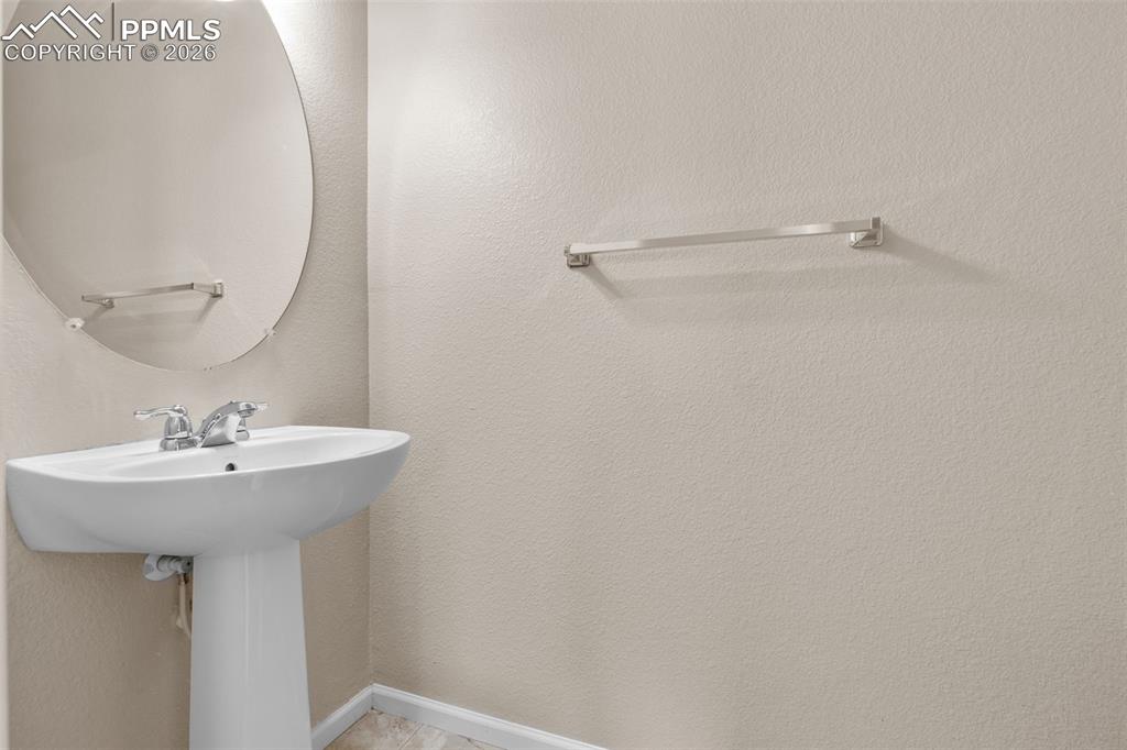 Main Level Half Bath with baseboards and a textured wall