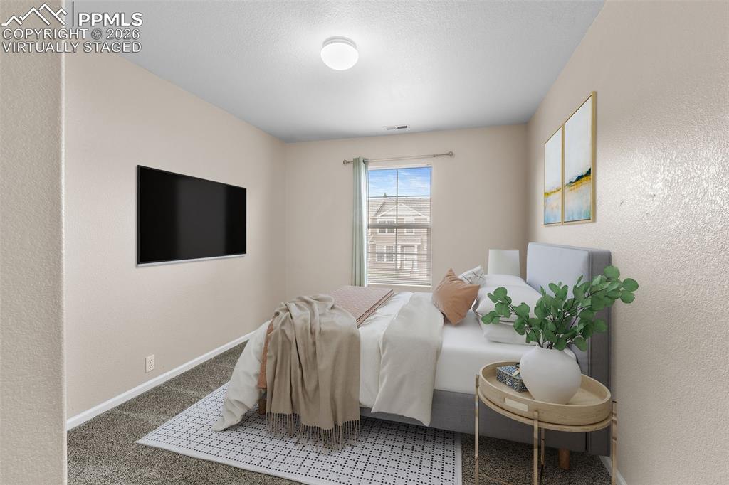 *Virtually Staged* Bedroom featuring a textured wall and carpet floors