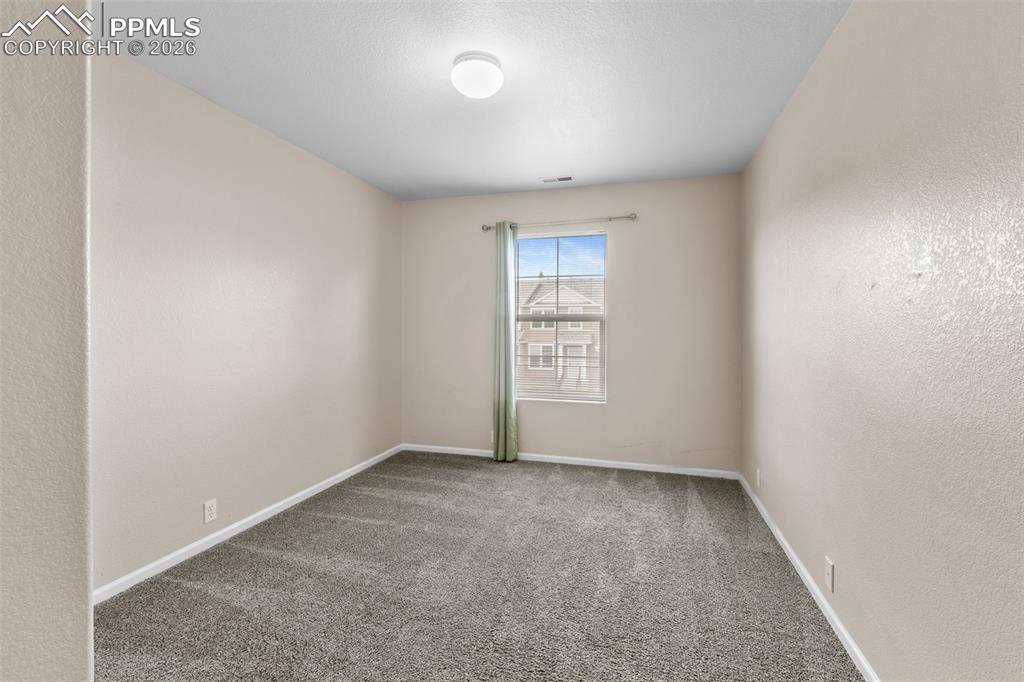 Carpeted empty room with a textured wall
