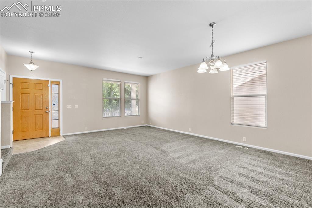 Unfurnished Dining room featuring carpet and a chandelier