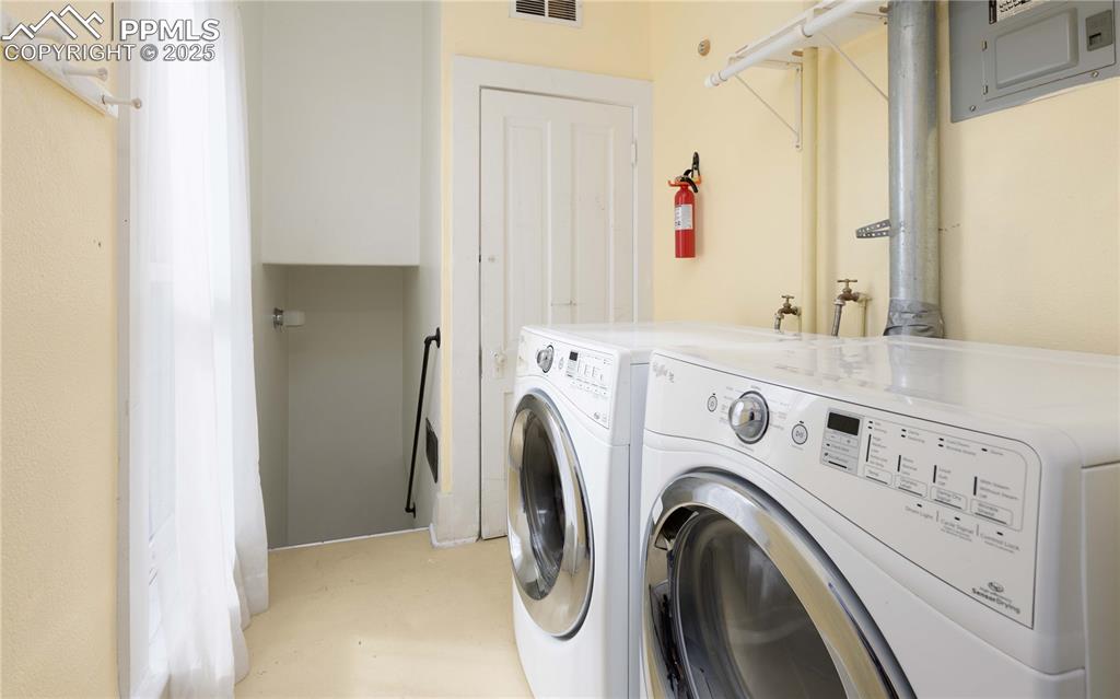 Washroom featuring washing machine and clothes dryer and electric panel