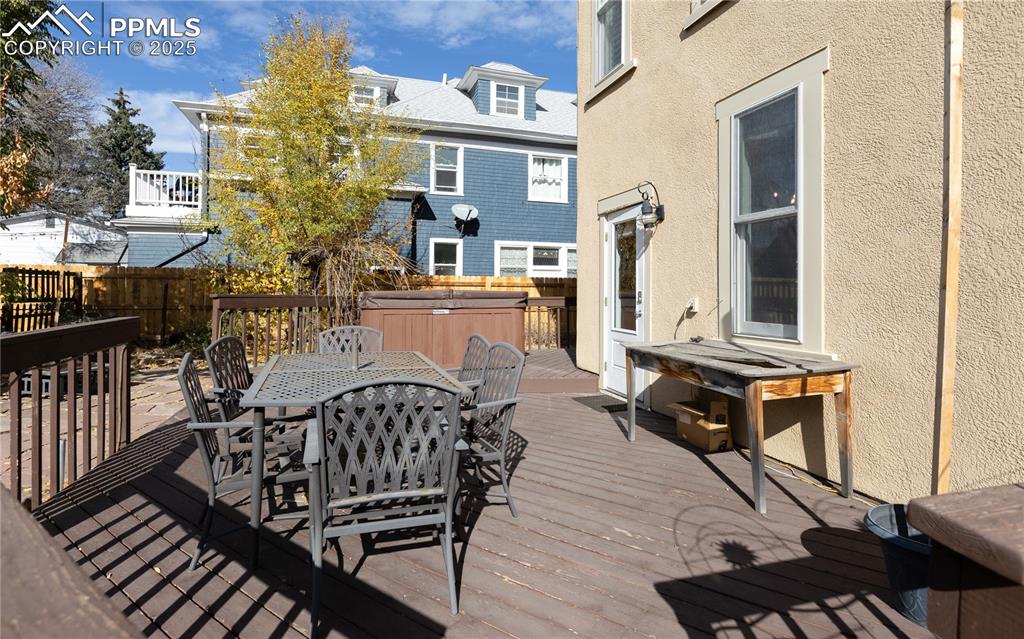 Wooden deck with a hot tub and outdoor dining area