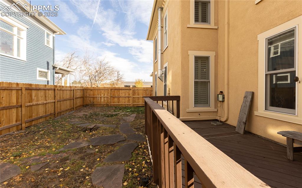 Wooden deck with a fenced backyard