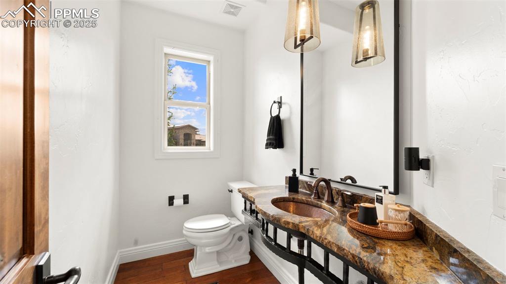 Half bath with dark wood-style floors and vanity