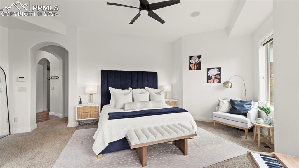 Bedroom with carpet, arched walkways, and a ceiling fan