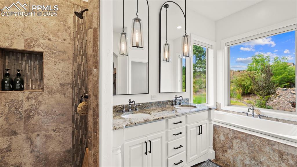 Full bathroom featuring walk in shower, a bath, and double vanity