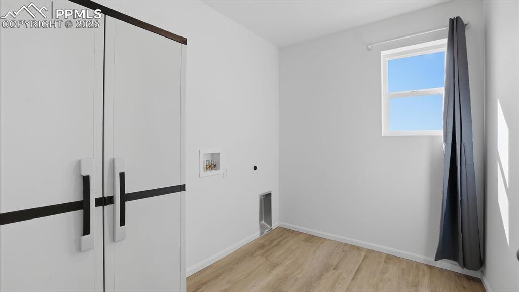 Upper Level Laundry Room with built-in cabinets, electrical hook up, and a window.