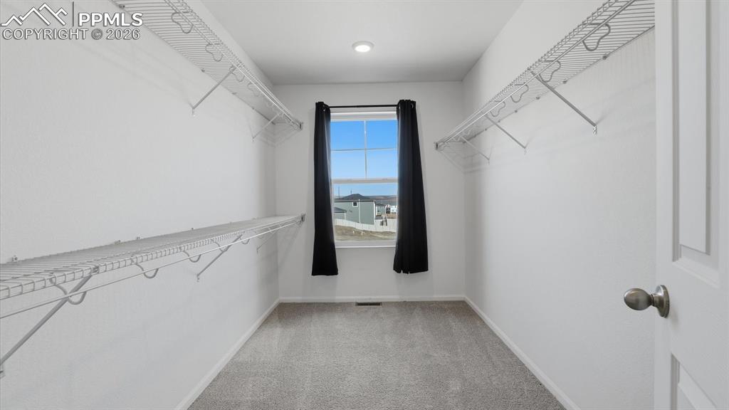 Huge walk in closet with built-in racks and window in the Primary Bedroom.