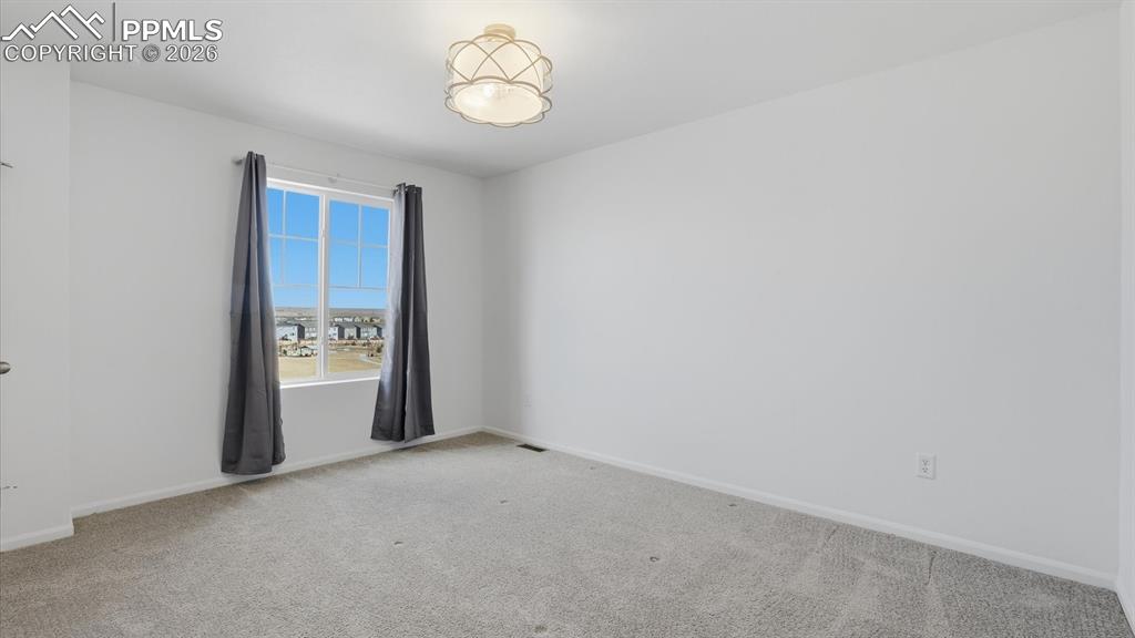 Upper Level Bedroom #3 with neutral carpet, walk in closet, and view window.