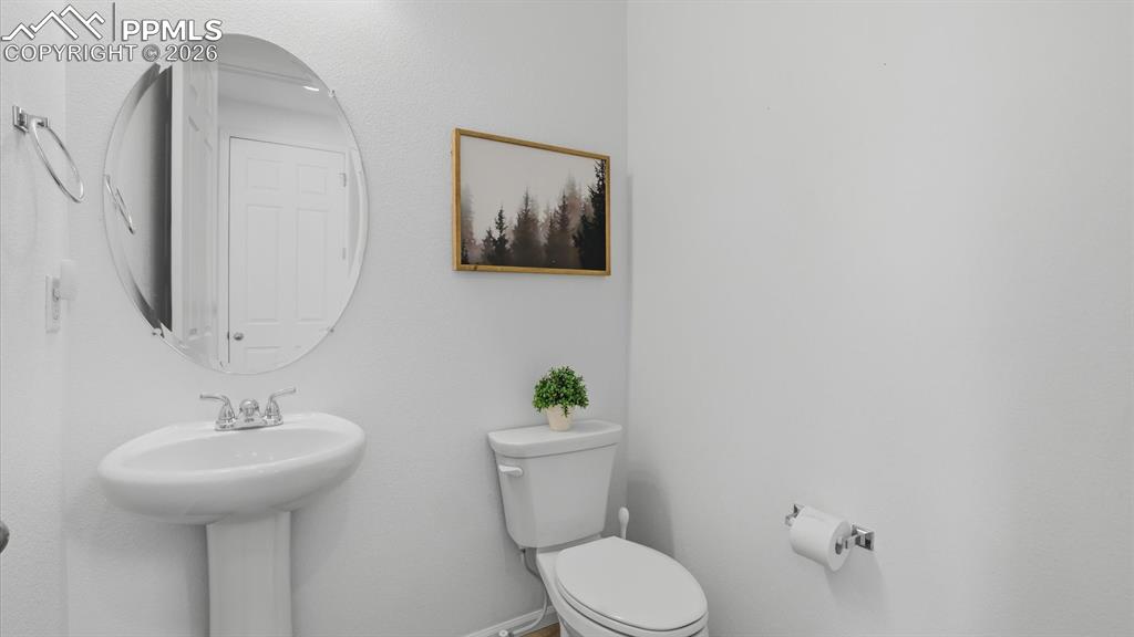 Powder Bathroom with pedestal sink and round mirror.
