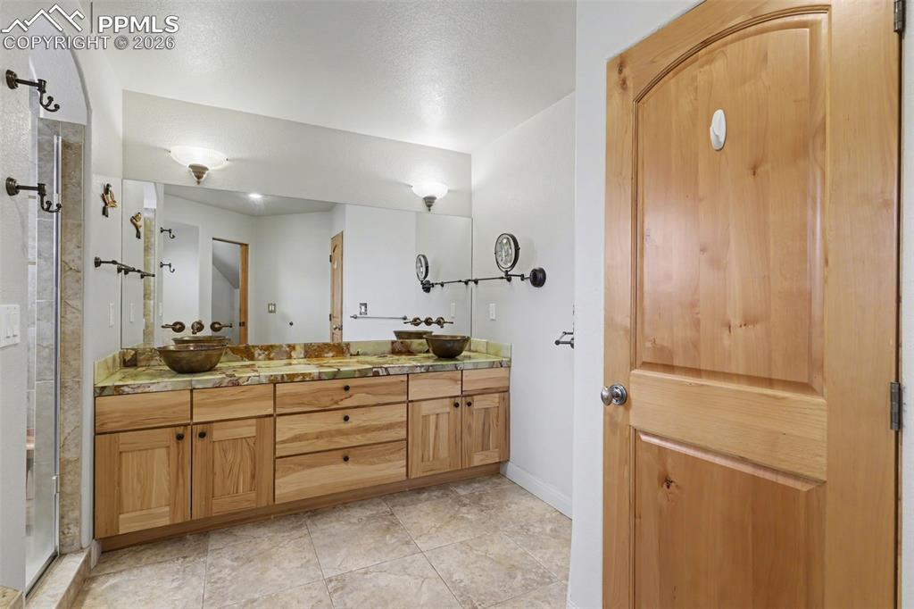 Lower level Full bathroom with vanity and enclosed tub / shower combo