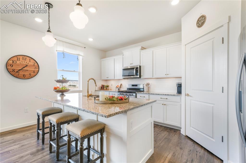 Kitchen with gas range, stainless appliances, walk in pantry, granite countertops, large center island, under cabinet lighting