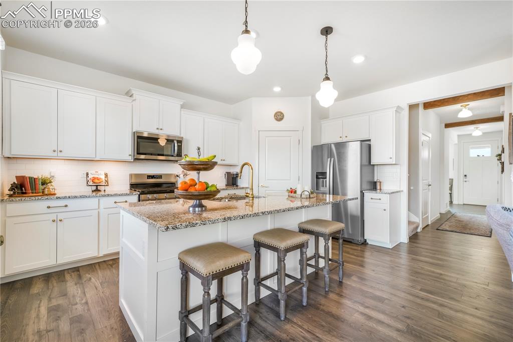 Kitchen with gas range, stainless appliances, walk in pantry, granite countertops, large center island, under cabinet lighting