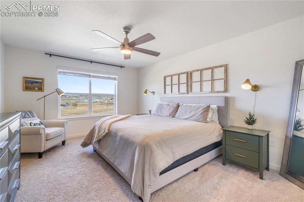 Upstairs primary bedroom with space for seating area, ensuite bathroom and views 