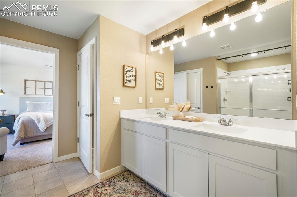 Primary bath with dual vanities, quartz counters, large walk in shower, separate water closet, linen closet and large walk in closet