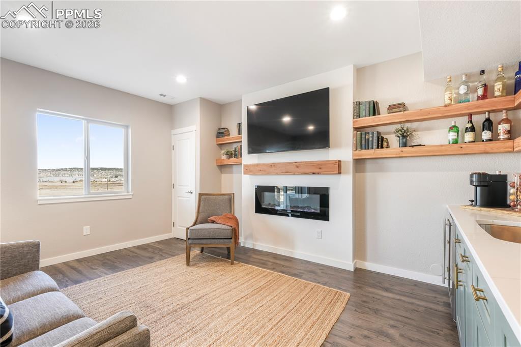 Walk out basement family room with electric fireplace and wet bar with quartz counters