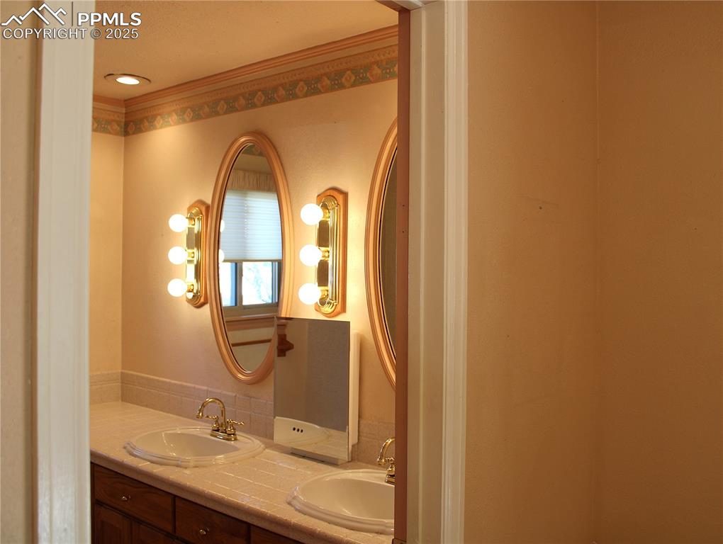 Primary Bathroom with double vanity and crown molding