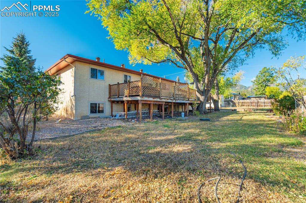 Rear view of property with a deck and stucco siding