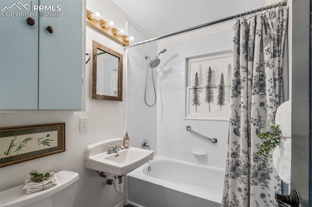 Bathroom with shower / tub combo with curtain and toilet